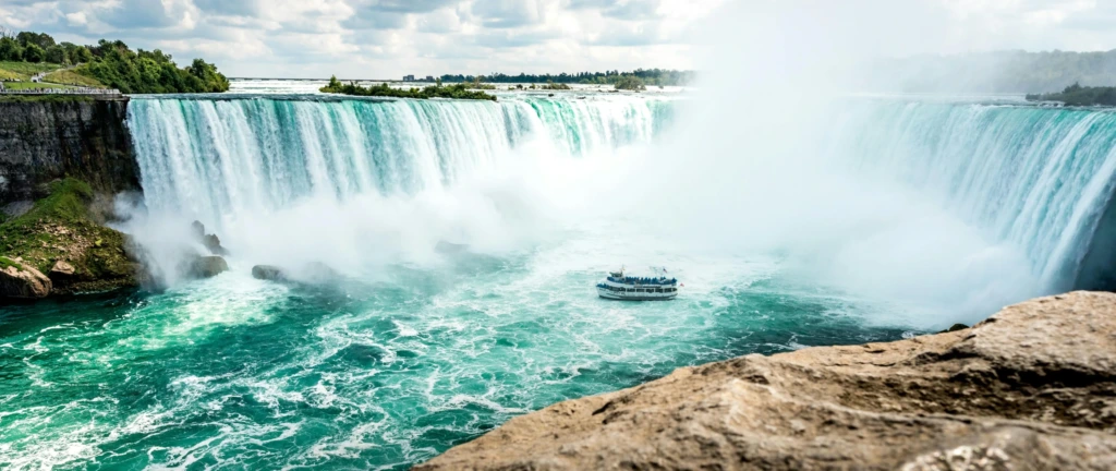 Niagara Şelalesi’nde yoğun su buharı ve şelalenin altına yaklaşan turist teknesi.