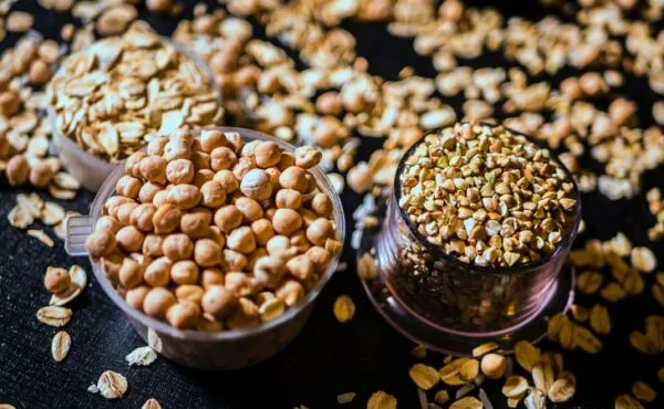 Nohut, yulaf ve karabuğday gibi vegan protein kaynakları siyah zeminde sergileniyor.