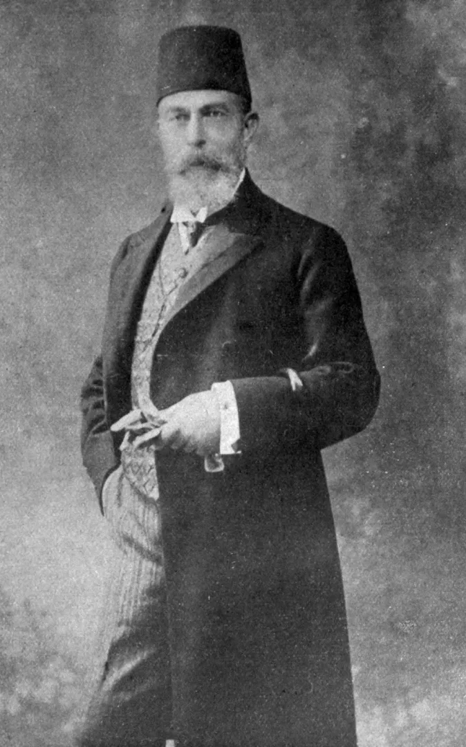 Recaizade Mahmud Ekrem'in fesli, uzun ve gür sakallı, şık redingotlu ve kravatlı olarak poz verdiği, hafifçe yan durup sağ elinde eldiven tuttuğu bu eski siyah beyaz portre fotoğrafı, edebiyatımızdaki önemli dönemi temsil etmektedir.