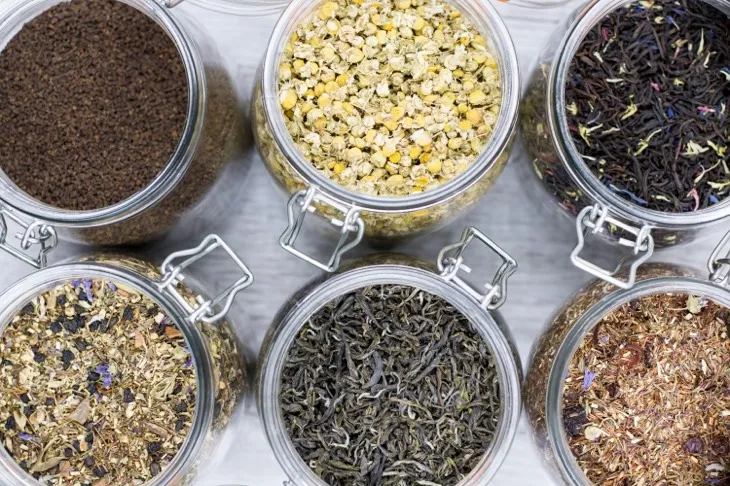 Kavanozlarda saklanmış çeşitli bitki çayları – papatya, siyah çay, rooibos ve bitki karışımları.