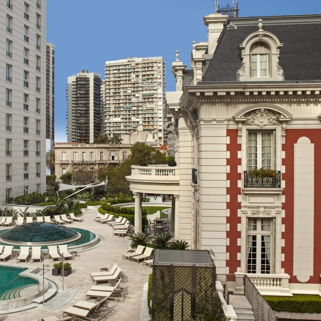 Four Seasons Hotel Buenos Aires'te, tarihi malikâne ve modern kule yapısının zarifçe birleştiği, havuzlu dış avluda sıralanmış şezlonglar ve yemyeşil bahçeler, şehrin sofistike ve kozmopolit enerjisini yansıtan lüks bir Buenos Aires konaklama deneyimi sunuyor.