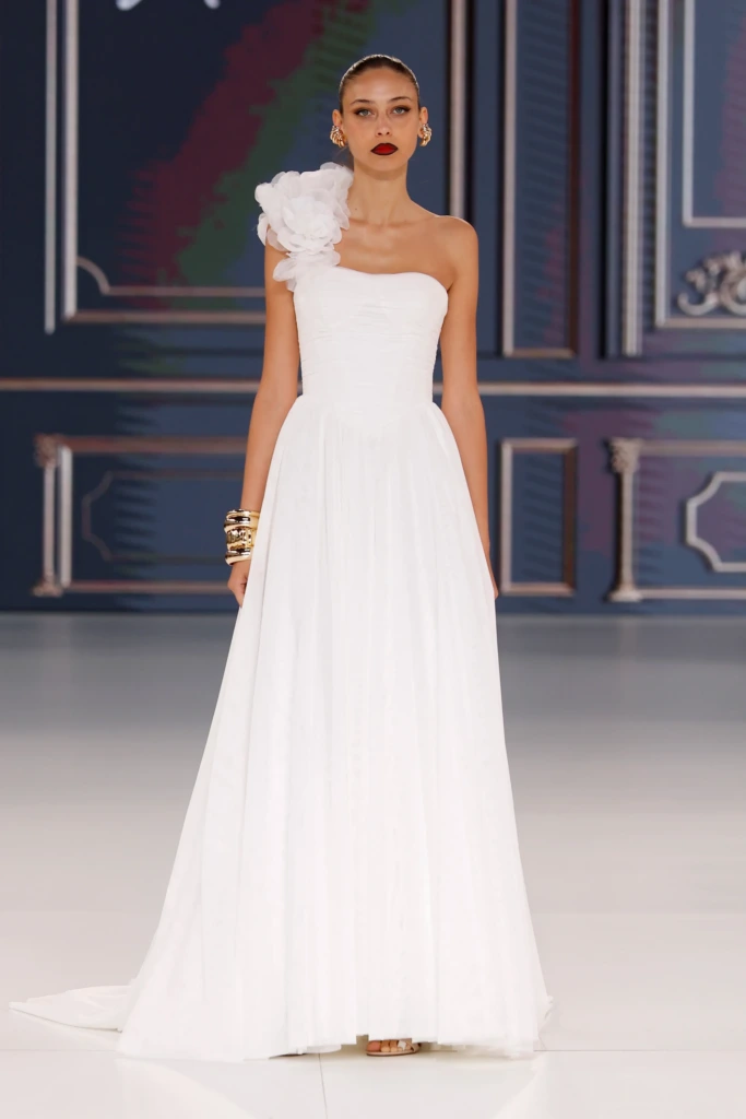 Allure Bridals tasarımı, tek omuzda çiçek detaylı, drapeli kumaşlı zarif ve sade gelinlik modeli.