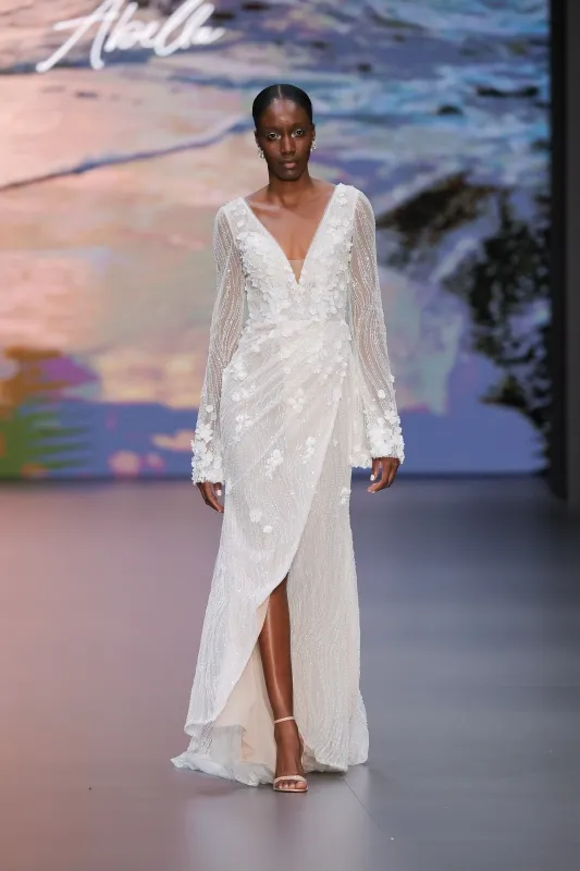 Allure Bridals imzalı, derin V yaka ve uzun kollu, transparan efektli drape detaylı, çiçek aplikeli modern gelinlik tasarımı.