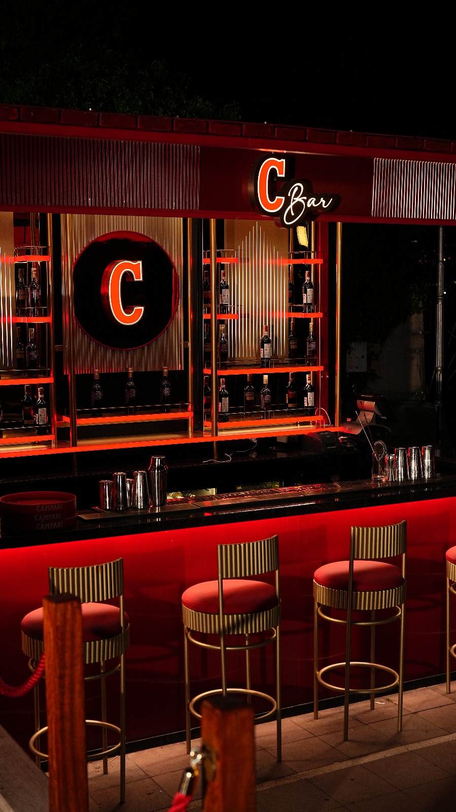 İstanbul'un en iyi teraslı mekanları arasında yer alan C Bar, kırmızı ışıklarla aydınlatılmış tezgahı, parlak altın detaylı bar tabureleri ve çeşitli şişelerle dolu şık raflarıyla geceleri göz alıcı bir atmosfer sunuyor.
