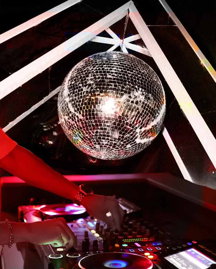 Bir DJ'in elleri loş kırmızı ışıklar altında bir mikseri ayarlarken, yukarıda dönen disko topu yansımalarla dans edenleri aydınlatıyor, Çeşme'nin en hareketli happy hour ve gece mekanlarındaki eğlenceyi canlı bir şekilde yansıtıyor.