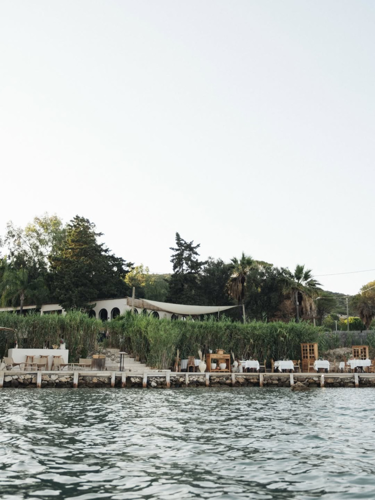 Çeşme/Alaçatı'nın romantik restoranlarından biri olan Meftun Alaçatı'nın denize sıfır konumunda, yemyeşil bitki örtüsü ve bembeyaz örtülü masalarıyla çevrili huzurlu dış mekan alanı, romantik bir akşam yemeği deneyimi sunuyor.