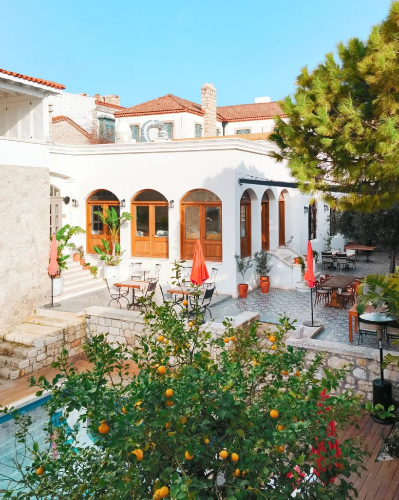 Alaçatı/Çeşme'nin en romantik restoranlarından biri olan Meftun'un, ön planda yer alan bol meyveli turunç ağacı ve mavi havuzun eşlik ettiği geniş avlusunda, beyaz taş duvarlı tarihi binanın önündeki zarif masalar keyifli anlar için davetkar bir ortam sunuyor.