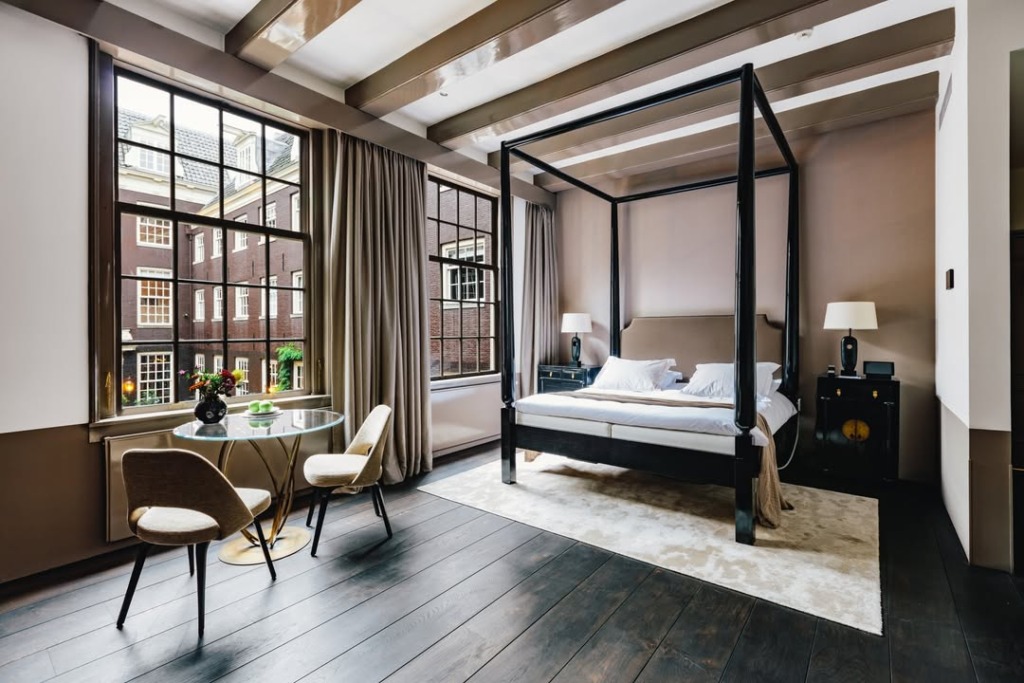 Marka Adı: The Dylan Hotel
Ürün Cinsiyeti: Belirtilmemiş
Ürün Tipi: Otel odası
Ürün Sezonsallığı: Belirtilmemiş
Ürün Çeşidi: Konaklama birimi
Ürün Özellikleri: Bu lüks otel odası, klasik ve modern detayların sofistike bir birleşimini sunar. Odada, koyu renk ahşap çerçeveli, bej yatak başlığına sahip gösterişli bir karyola bulunmaktadır. Yatak, beyaz nevresimler ve yumuşak, açık kahve tonlarında bir battaniye ile donatılmıştır. Her iki yatak yanında, zarif abajurlara sahip, koyu renk ahşap komodinler yer alır; bunlardan birinde altın rengi dekoratif bir detay dikkat çeker. Oda zemini koyu renk ahşap parke ile kaplı olup, yatağın altında açık krem rengi, yumuşak dokulu bir halı bulunur. İç avluya bakan, geleneksel tuğla binaların manzarasını sunan iki adet geniş, çok bölmeli pencere odaya bol ışık verir ve odanın dingin atmosferine katkıda bulunur. Pencerelerin önünde, altın rengi zarif ayaklara sahip yuvarlak cam bir masa ve bej kumaş döşemeli iki sandalye, keyifli bir oturma alanı oluşturur. Duvarlar alt kısımda koyu kahve, üst kısımda ise daha açık, sıcak bir bej tonunda boyanmıştır. Tavanı süsleyen parlak kahve tonlarındaki ahşap kirişler, odanın şık ve karakterli mimarisini vurgular. Oda, 17. yüzyıldan kalma tarihi bir yapının modern bir butik otel odasına dönüşümünü yansıtmaktadır.
Öne Çıkan Detaylar:
- Zarif ve gösterişli koyu renk ahşap karyola
- İç avlu manzaralı, geniş, çok bölmeli pencereler
- Tarihi binanın mimarisine uygun sofistike iki tonlu duvarlar ve parlak ahşap tavan kirişleri
Kimler Kullanıyor?: Amsterdam'ın zengin tarihi dokusunu, modern lüks ve kişiselleştirilmiş butik otel konforuyla birleştirmek isteyen, detaylara ve estetiğe önem veren gezginler bu otel odasını tercih edebilir. Şehrin kalbinde, kültürel ve sanatsal keşiflere yakın olmayı arzulayan, aynı zamanda sakin ve stil sahibi bir ortamda dinlenmeyi seven bireyler ve çiftler için idealdir. Konakladıkları yerin sadece bir oda değil, aynı zamanda şehrin ruhunu yansıtan özel bir deneyim olmasını bekleyen misafirler için mükemmel bir seçenektir.