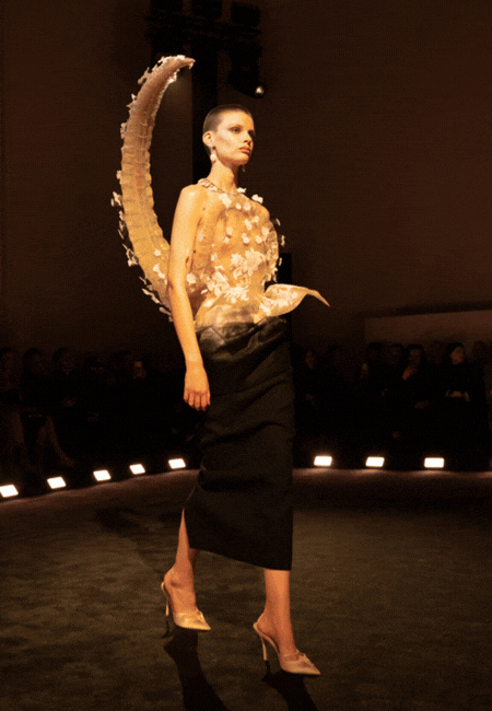 Schiaparelli 2026 İlkbahar-Yaz haute couture defilesi podyum görünümü: Heykelsi formda, transparan detaylı üst ve siyah etekle sunulan avangart tasarım