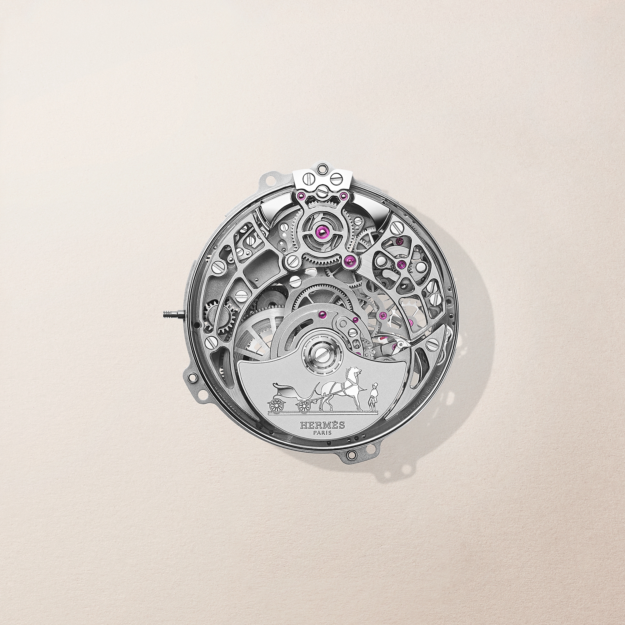 Bu yakın çekim görüntü, Arceau Samarcande'ın Hermès H1927 kalibre otomatik mekanizmasını, sayısız dişli, köprü, vida ve pembe mücevher yataklarıyla karmaşık bir şekilde işlenmiş, markanın binicilik mirasını yansıtan atlı araba logolu mikro-rotoruyla yüksek zanaatkârlık ve saatçilik ustalığını gözler önüne seriyor.