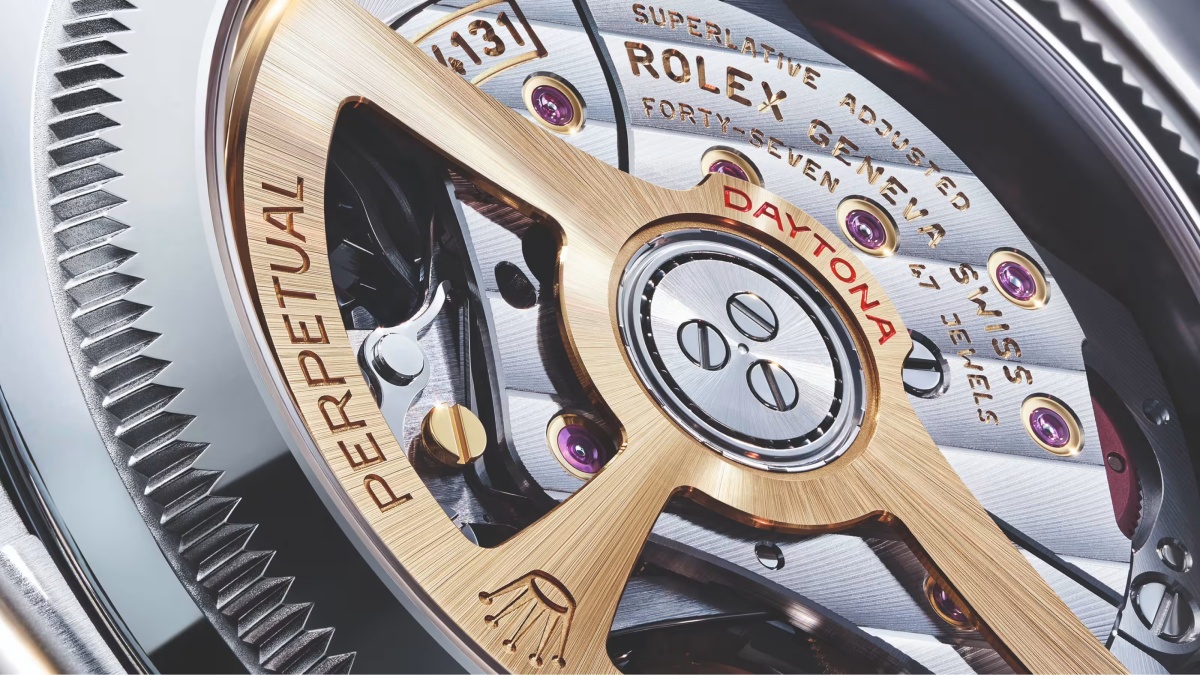 Altın rengi PERPETUAL yazılı Rolex salınım ağırlığı ve DAYTONA ibaresiyle, mor yakut taşlar ve karmaşık dişlilerin net göründüğü, üstün ayarlı bir Rolex Cosmograph Daytona kronograf saat mekanizması detayı.