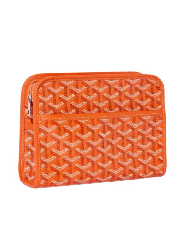Parlak turuncu renkteki lüks bir Goyard çanta, markanın özgün Y şeklindeki monogram desenleriyle kaplı yüzeyi, metal fermuarı ve açık renk dikiş detaylarıyla beyaz bir zeminde şık bir şekilde sergileniyor.