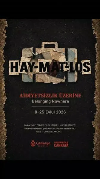 Koyu, dokulu bir arka plan üzerinde, yırtık kağıt parçalarından yapılmış gibi duran eski bir bavul figürü ve üzerinde HAY-MAT-LOS kelimesinin parçalı harflerle yazılı olduğu, aidiyetsizlik temalı bir serginin afişi. Bu afiş, Çankaya Belediyesi Zülfü Livaneli Kültür Merkezi'nde 8-25 Eylül 2026 tarihleri arasında düzenlenecek Haymatlos: Aidiyetsizlik Üzerine sergisini duyuruyor.