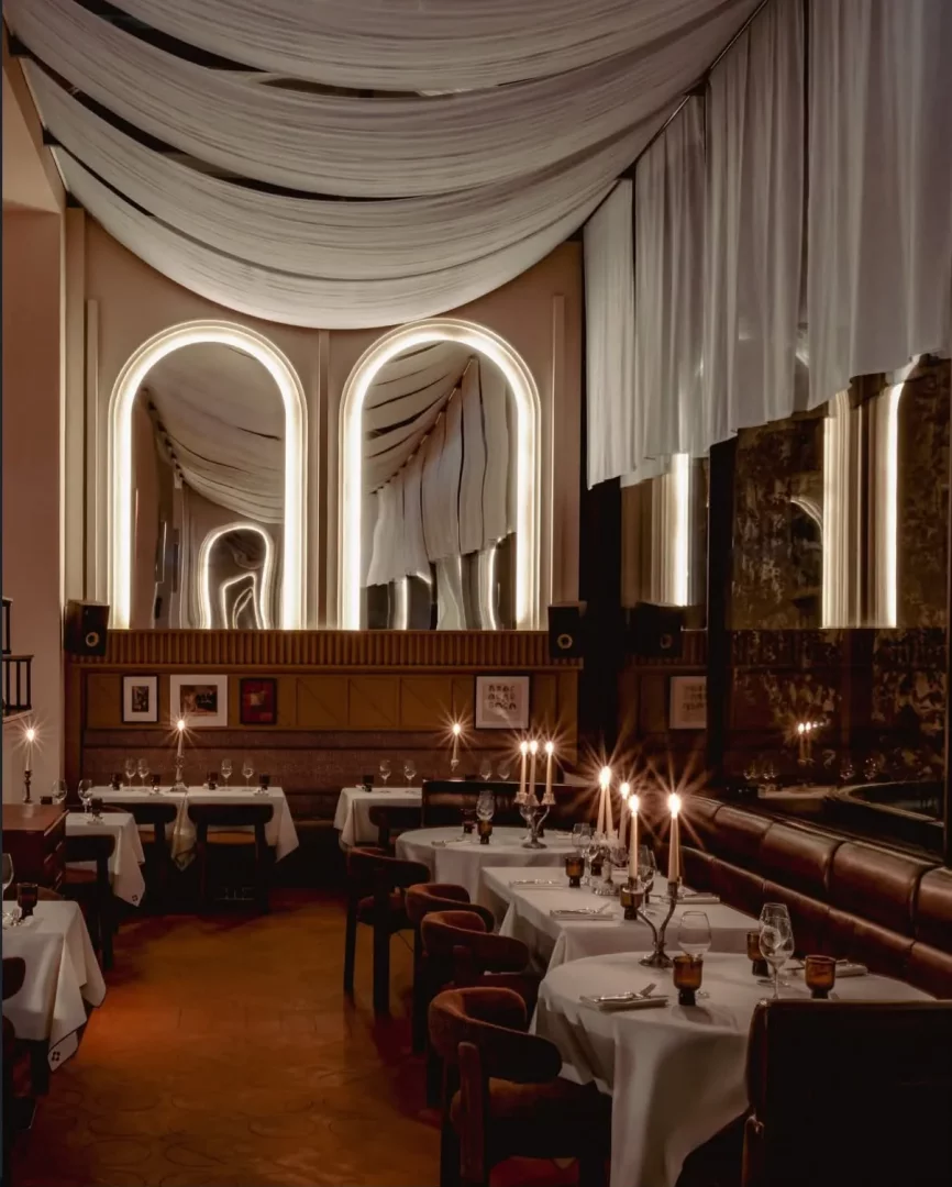 Marais’nin kalbindeki Temple & Chapon’un, 1950’lerin New York chophouse ruhunu yansıtan etkileyici dekorasyonunda, aydınlatılmış kemerli aynalar ve tavandaki zarif drapelerle süslü loş ortamda, mum ışığında uzun bir akşam geçirmek için hazırlanmış beyaz örtülü masalar ve kahverengi kadife sandalyeler yer alıyor.