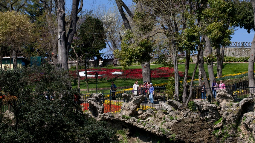 Yemyeşil ağaçların ve rengarenk lalelerin süslediği Yıldız Parkı'nda, kırmızı ve beyaz lalelerden özenle oluşturulmuş Türk bayrağı motifli çiçek tarhının önünde yürüyen ve manzarayı seyreden ziyaretçiler baharın tadını çıkarıyor.