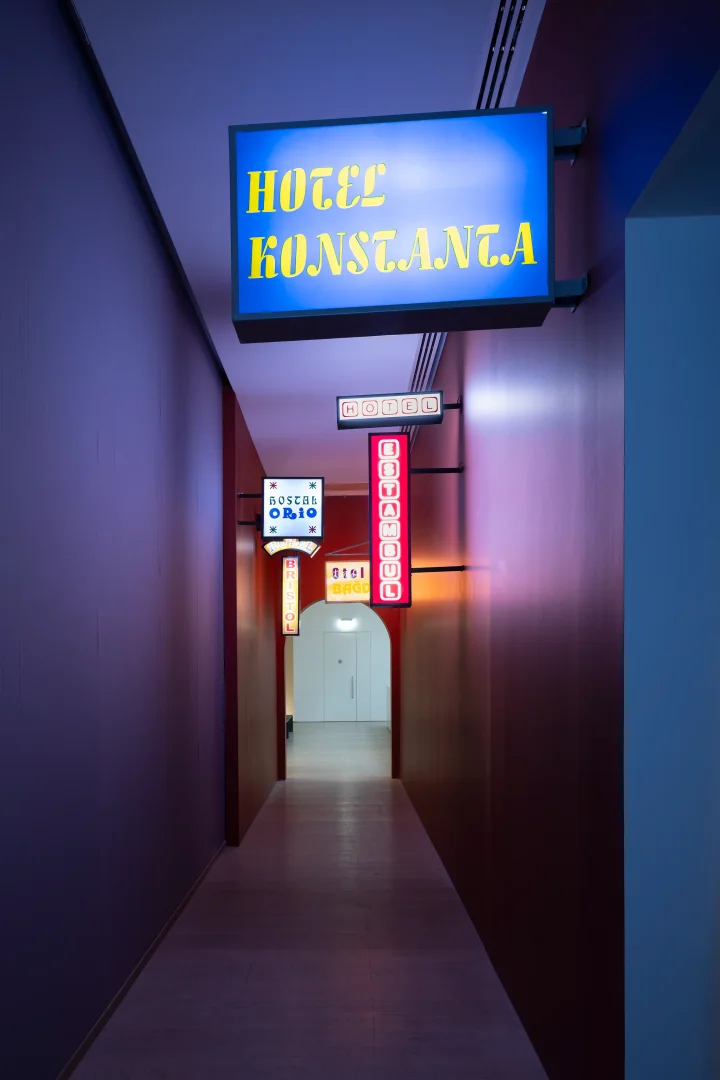 Soluk mor ve kahverengi tonlardaki duvarlarla çevrili uzun bir koridorda, HOTEL KONSTANTA, İSTANBUL ve HOTEL BRISTOL gibi farklı boyut ve renklerde birçok eski stil ışıklı otel tabelası kemerli bir kapıya doğru uzanarak Beyoğlu’nun zengin kültürel hafızası içinde otellerin dönüşümünü ve geçmişle bağını çağdaş bir sergi kurulumuyla gözler önüne seriyor.