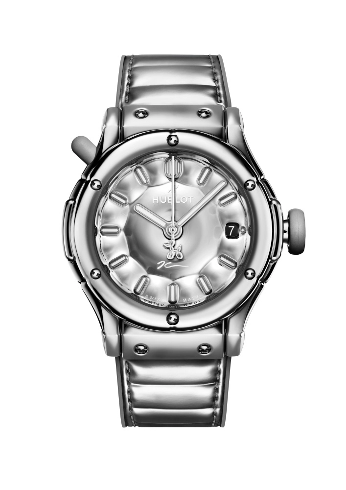 Parlak gümüş rengi Hublot Classic Fusion kol saati, kadranında Jeff Koons'un imzasını ve Balon Köpek figürünü taşıyan, şişkin, parlak metalik kasası ve kayışıyla, saat 3 yönünde tarih penceresi bulunan sanatsal bir tasarım sunuyor.
