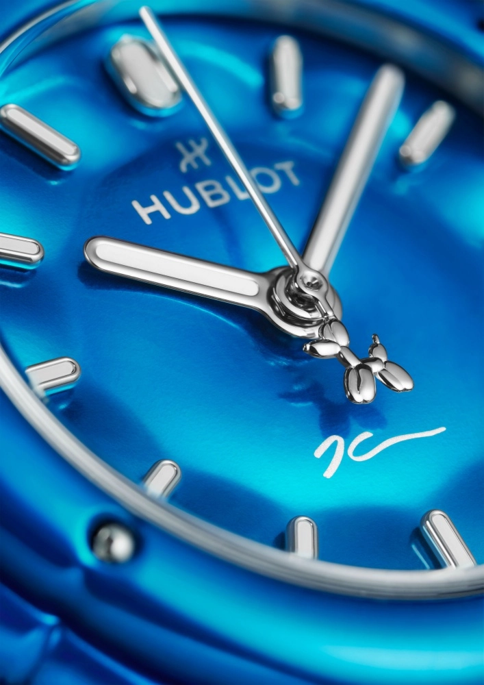 Hublot Classic Fusion modelinin canlı mavi kadranında, gümüş renkli saat imleri ve kollarının yanı sıra, saniye ibresinin merkezine entegre edilmiş Jeff Koons'un imza balon köpek figürü ve kadranın alt kısmında sanatçının el yazısı imzası yer almaktadır.