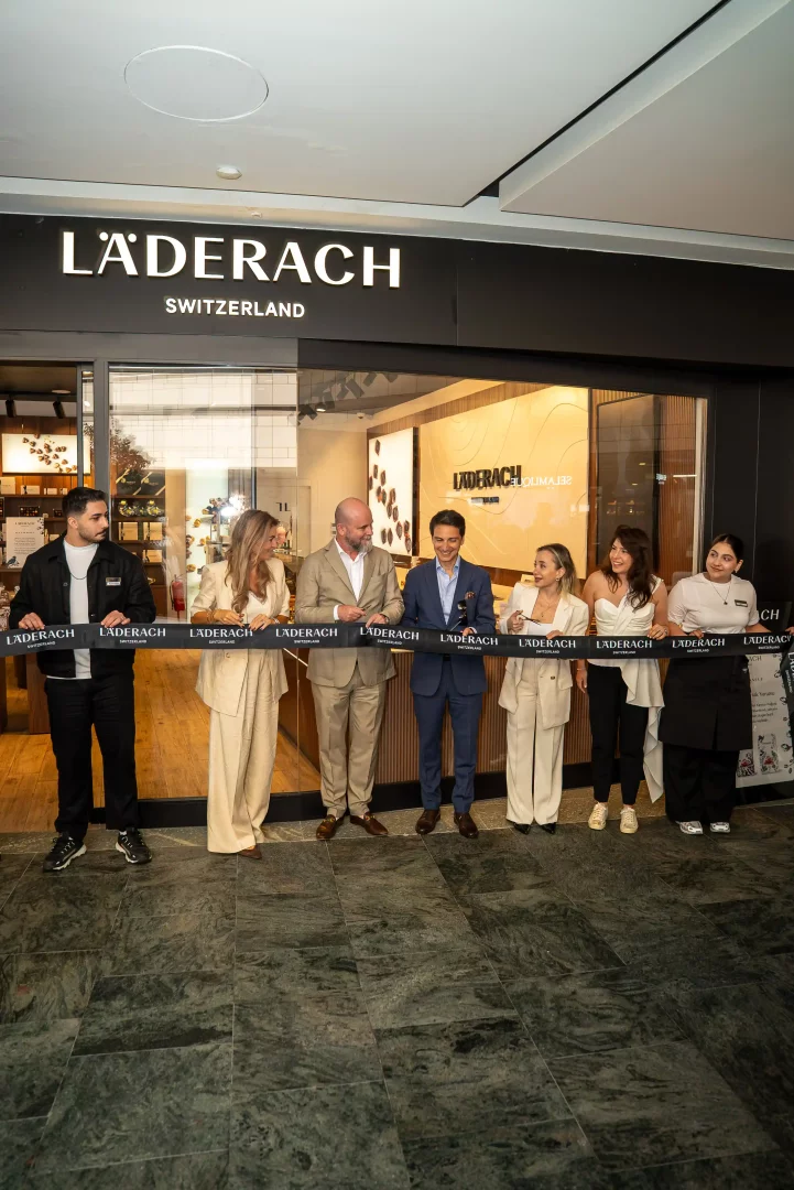 Läderach Switzerland mağazasının açılış töreninde, iyi çikolatanın kakao ve zanaatla buluştuğu bu markanın küresel genişlemesini temsil eden bir grup çalışan ve yöneticinin kurdele kestiği an görülüyor.