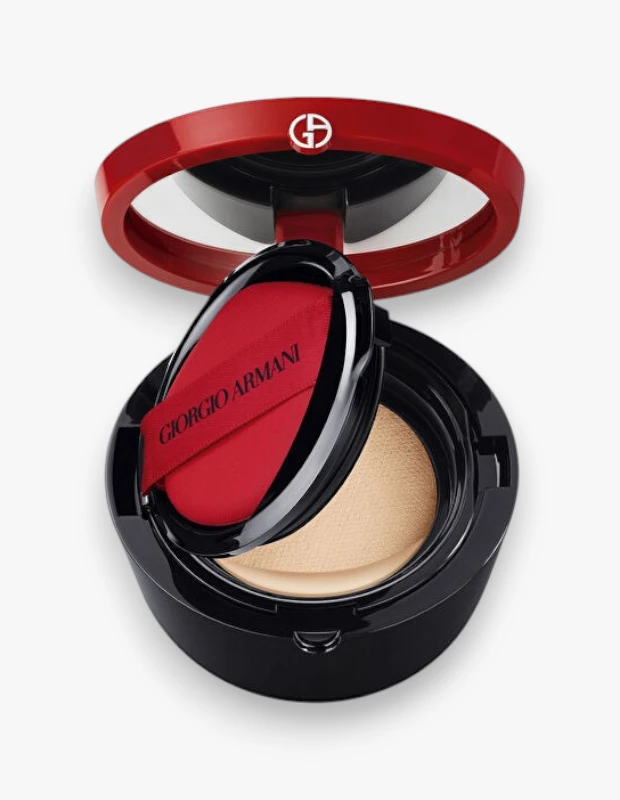 Açık kırmızı kapaklı siyah Giorgio Armani My Armani To Go cushion fondöten kabı, içinde açık bej rengi fondöten ve üzerinde markanın adı yazan kırmızı aplikatör süngeriyle beyaz bir arka planda özenle sergileniyor.