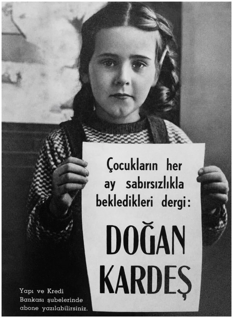 Yüzyılın İzleri sergisi içeriğiyle uyumlu, siyah beyaz bir fotoğrafta örgülü saçlı küçük bir kız çocuğu, çocukların sabırsızlıkla beklediği Doğan Kardeş dergisinin reklam panosunu ciddi bir ifadeyle tutarken görülüyor, bu görsel Koç Topluluğu'nun kültürel katkılarının ve geçmişe dair izlerinin çocuk gözünden yansımalarını sunuyor.