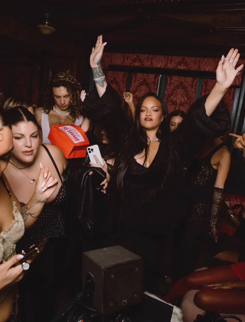 Ortamın loş kırmızı ışığında, kollarını havaya kaldırmış şarkıcı Rihanna, kadife dokulu duvarları olan bir Paris mekanında kalabalık içinde kendine güvenli bir ifadeyle poz verirken, etrafındaki misafirler de eğlenceli anın tadını çıkarıyor, Lapérouse'daki gece hayatının hareketliliğini yansıtıyor.