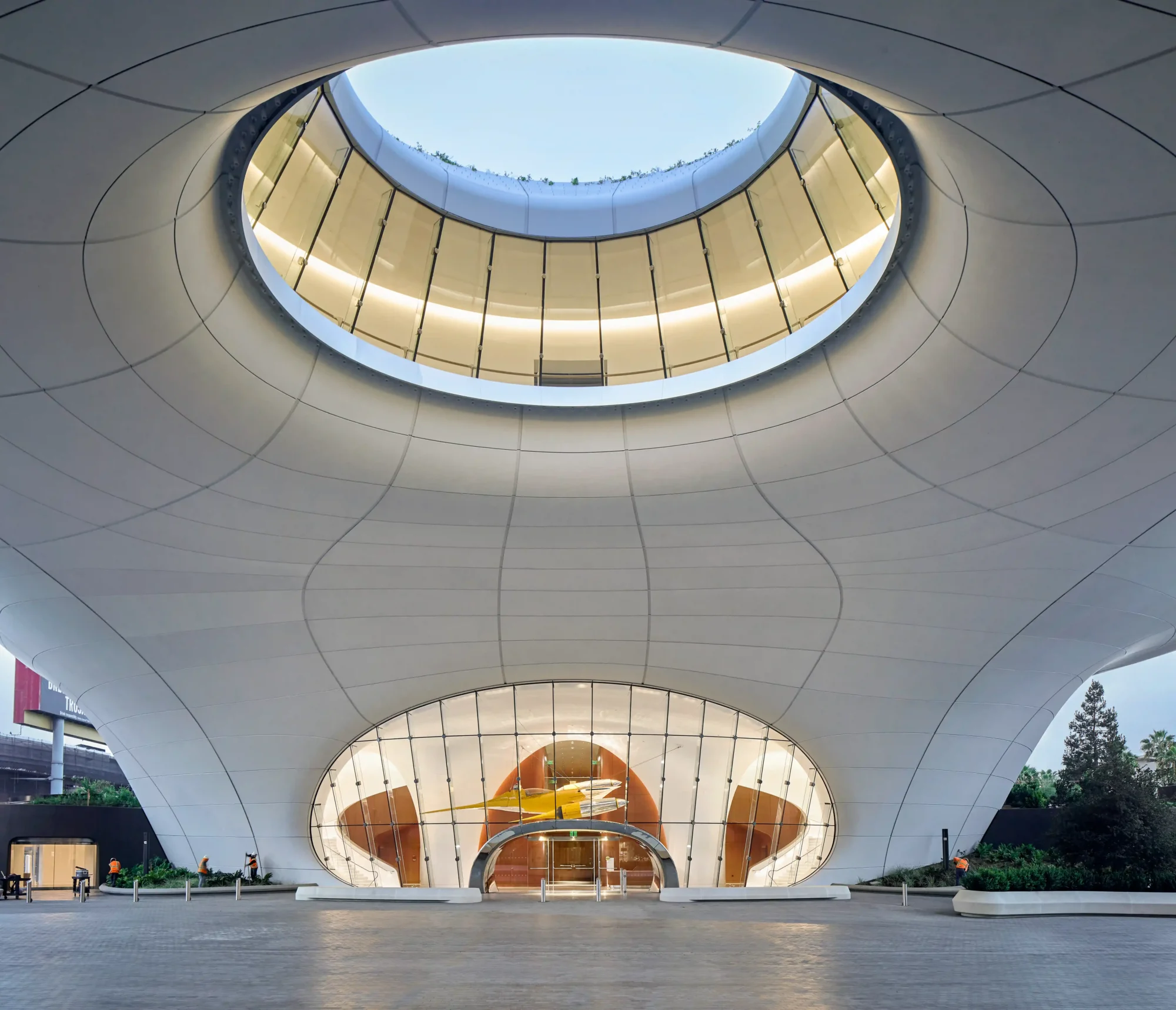 Lucas Museum of Narrative Art'ın Ma Yansong imzalı, bulutları andıran beyaz mimarisi, tepesindeki devasa yuvarlak boşluk ve camlı girişinden görünen sarı bir Star Wars savaş gemisiyle George Lucas'ın biriktirdiği hayali dünyalara açılan kapıyı gösteriyor.