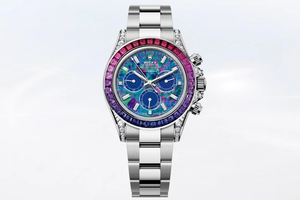 Parlak metal bilezikli, pembe, mor ve mavi tonlarda gradyan renkli değerli taşlarla bezeli, yan kısımları pırlantalı ve opal benzeri canlı renkli bir kadrana sahip bu özel Rolex Daytona saati, Dört Mevsim estetiğini yansıtıyor.