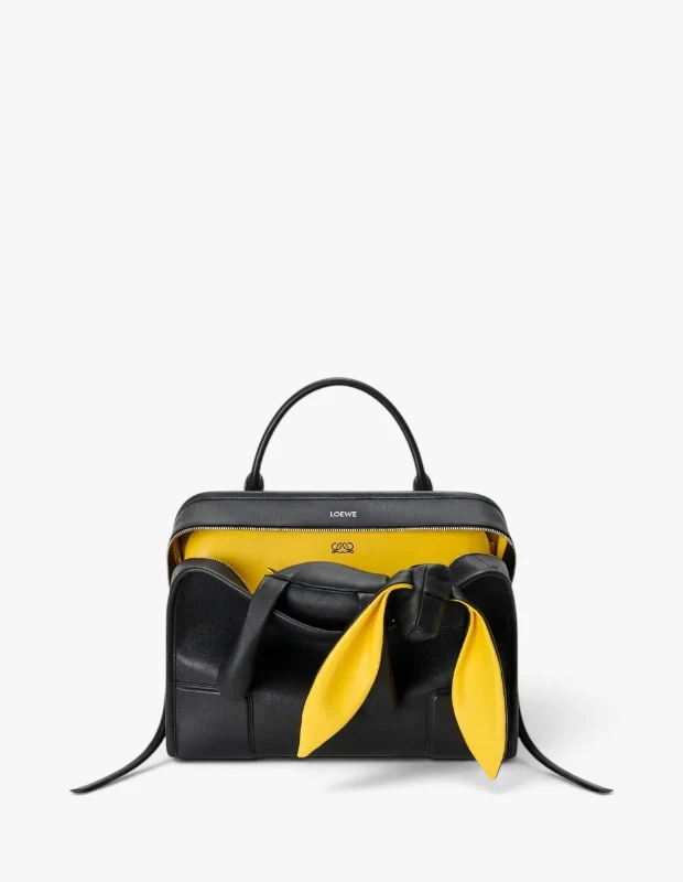 Marka Adı: Loewe
Ürün Adı: Loewe Large Amazona 180 Lazy Dog
Ürün Cinsiyeti: Kadın
Ürün Tipi: Üstten Saplı Çanta
Ürün Sezonsallığı: Sonbahar-Kış
Ürün Çeşidi: Deri Çanta
Ürün Özellikleri: Bu Loewe Large Amazona 180 Lazy Dog çanta, siyah buffalino deriden üretilmiş olup, yapısal ve dikdörtgen formuyla modern bir estetik sunar. Fermuarlı üst açıklığı, iç kısımda canlı sarı astarı ve 'Lazy Dog' temasını yansıtan oyunbaz sarı deri kulak detaylarıyla kontrast bir görünüm sergiler. Çift üst sapı sayesinde elde rahatça taşınabilirken, geniş iç hacmi günlük ihtiyaçlar için pratik kullanım sunar ve iç kısımda Loewe logosu bulunur.
Öne Çıkan Detaylar:
- Siyah buffalino deri dış yüzey ve kontrast oluşturan canlı sarı iç astar.
- Oyunbaz ve trendlere uygun 'Lazy Dog' sarı deri kulak detayı.
- Fermuarı açık bırakılarak kullanılan, 'dağınıklık serbest' akımına uyum sağlayan tasarım.
Kimler Kullanıyor?: Çağdaş lüksü ve sofistike duruşu sevenler, stilini özgün detaylarla kişiselleştirmeyi tercih edenler, işlevsellikten ödün vermeden güncel moda trendlerini takip eden ve kıyafetlerine eğlenceli bir dokunuş katmaktan çekinmeyen bireyler için idealdir.