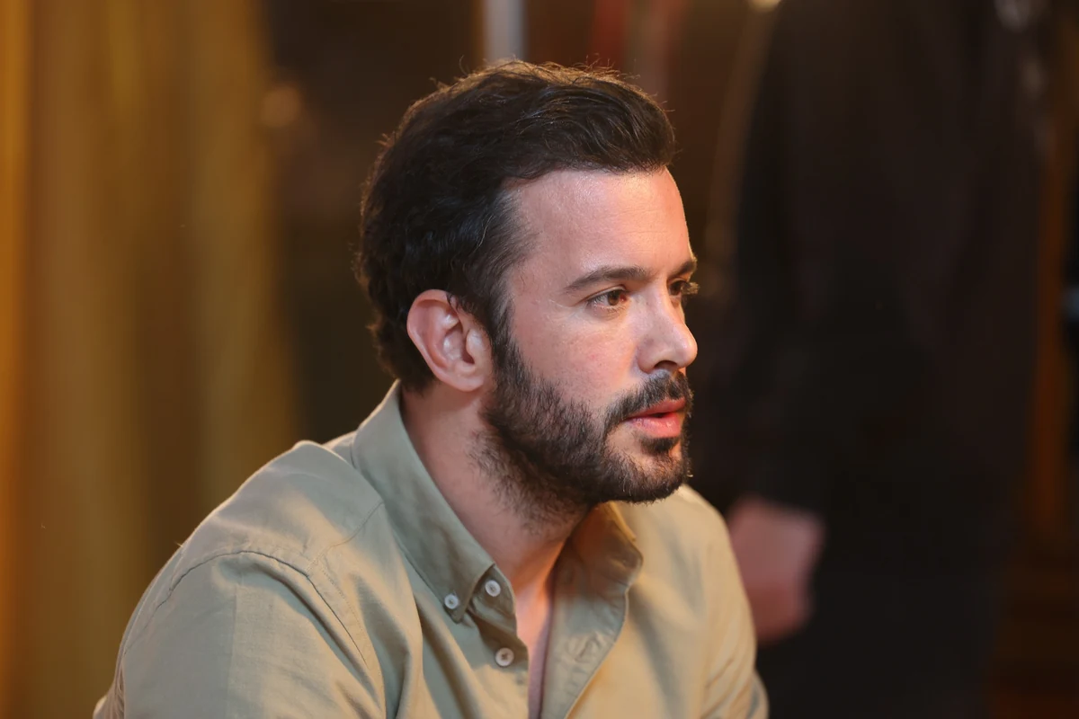 Barış Arduç, genellikle Soy filmi ile anılan ünlü bir oyuncu olarak, bu portre fotoğrafında yandan çekilmiş, koyu saçları ve bakımlı sakalıyla dikkat çekici bir ifadeyle sağa doğru bakarken açık renkli gömleğiyle doğal bir duruş sergiliyor.