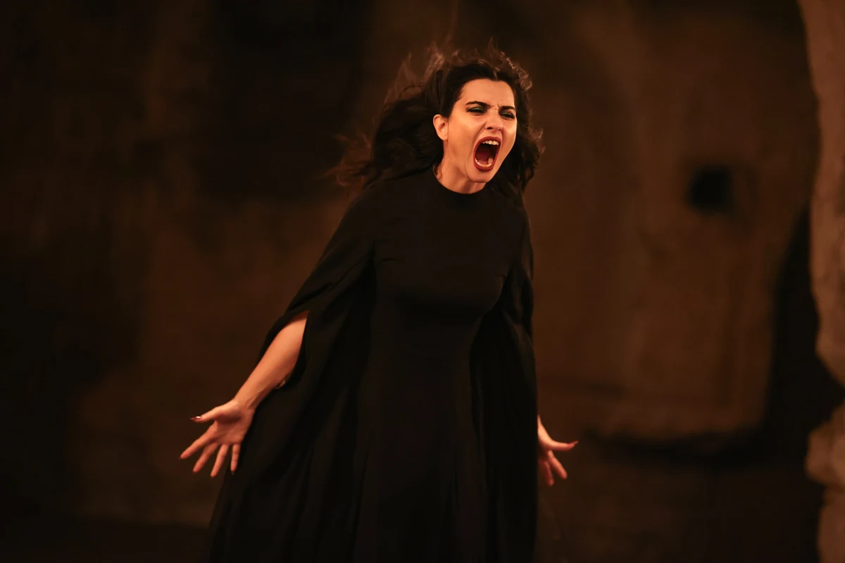 Soy Filmi'nden bir karede, Tuba Büyüküstün loş, koyu kahverengi bir mağara ortamında, omuzları pelerinli siyah elbisesi içinde, ağzı sonuna kadar açık, dişleri görünür ve saçları savrulmuş halde acıyla veya öfkeyle çığlık atıyor, elleri dışa doğru açık.